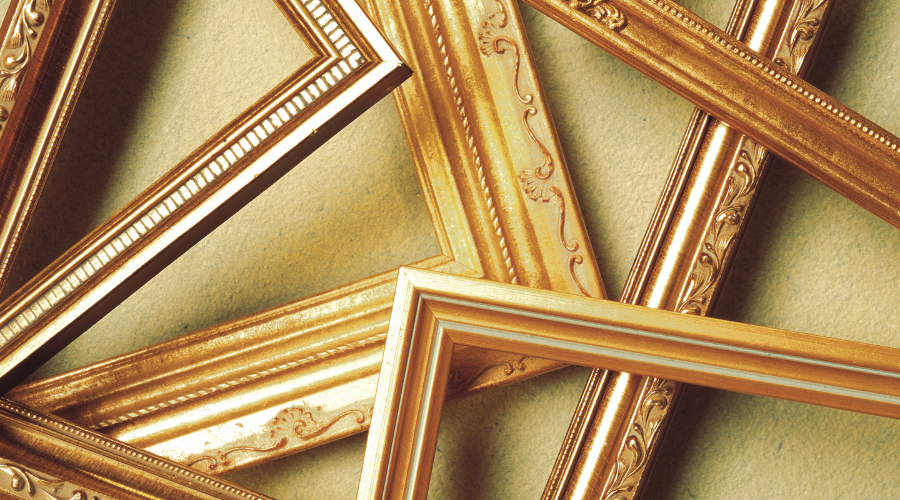 A pile of empty gold picture frames.